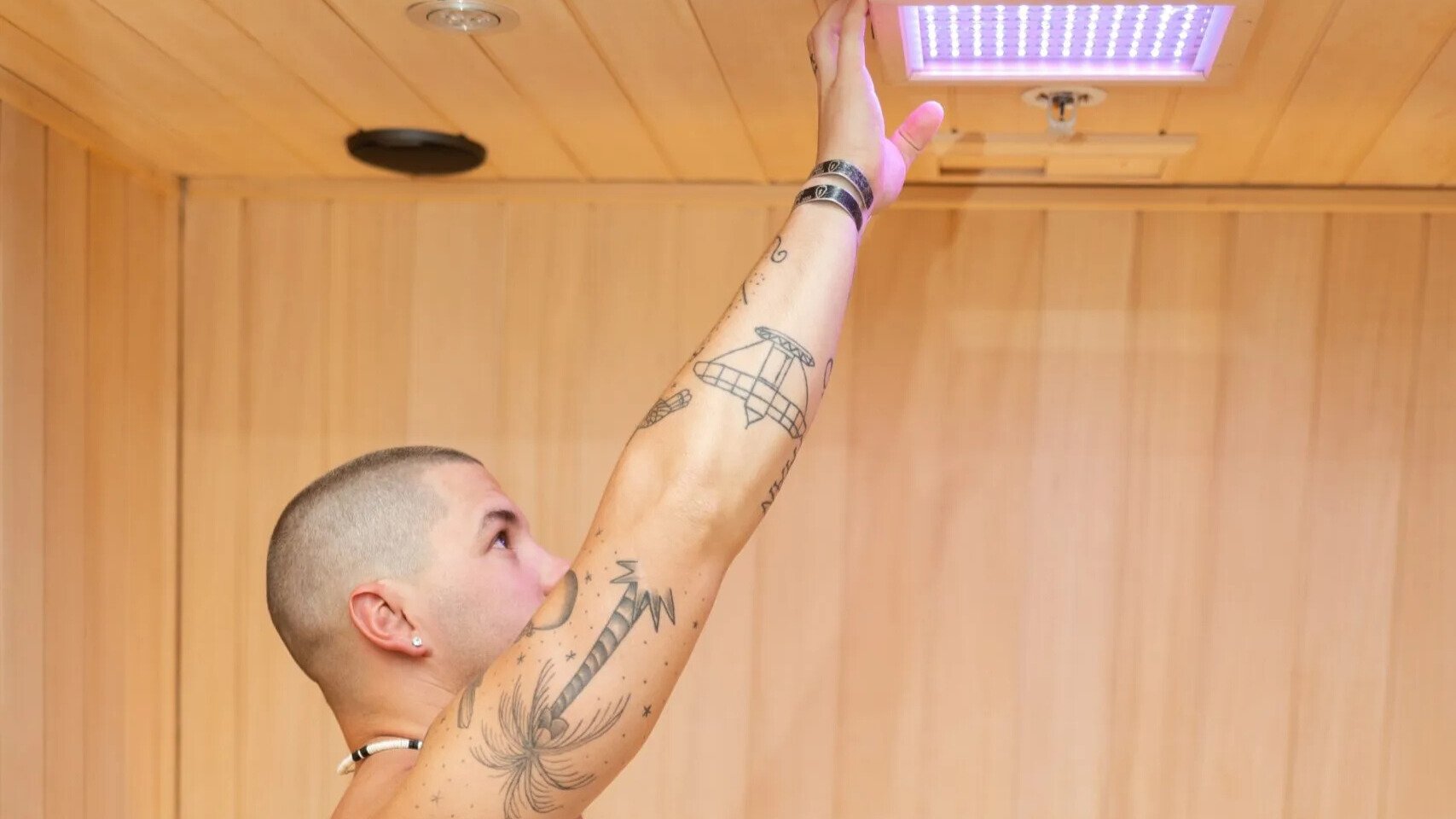 Man adjusting light in sauna for chromotherapy.