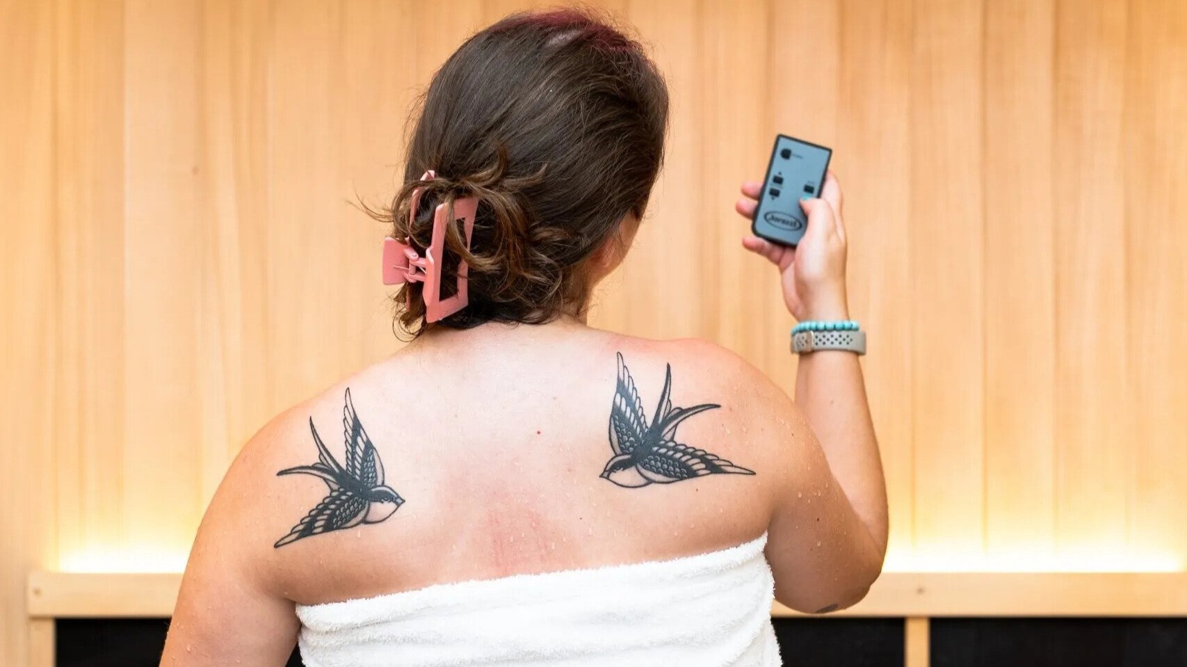 woman in the sauna looking at her phone
