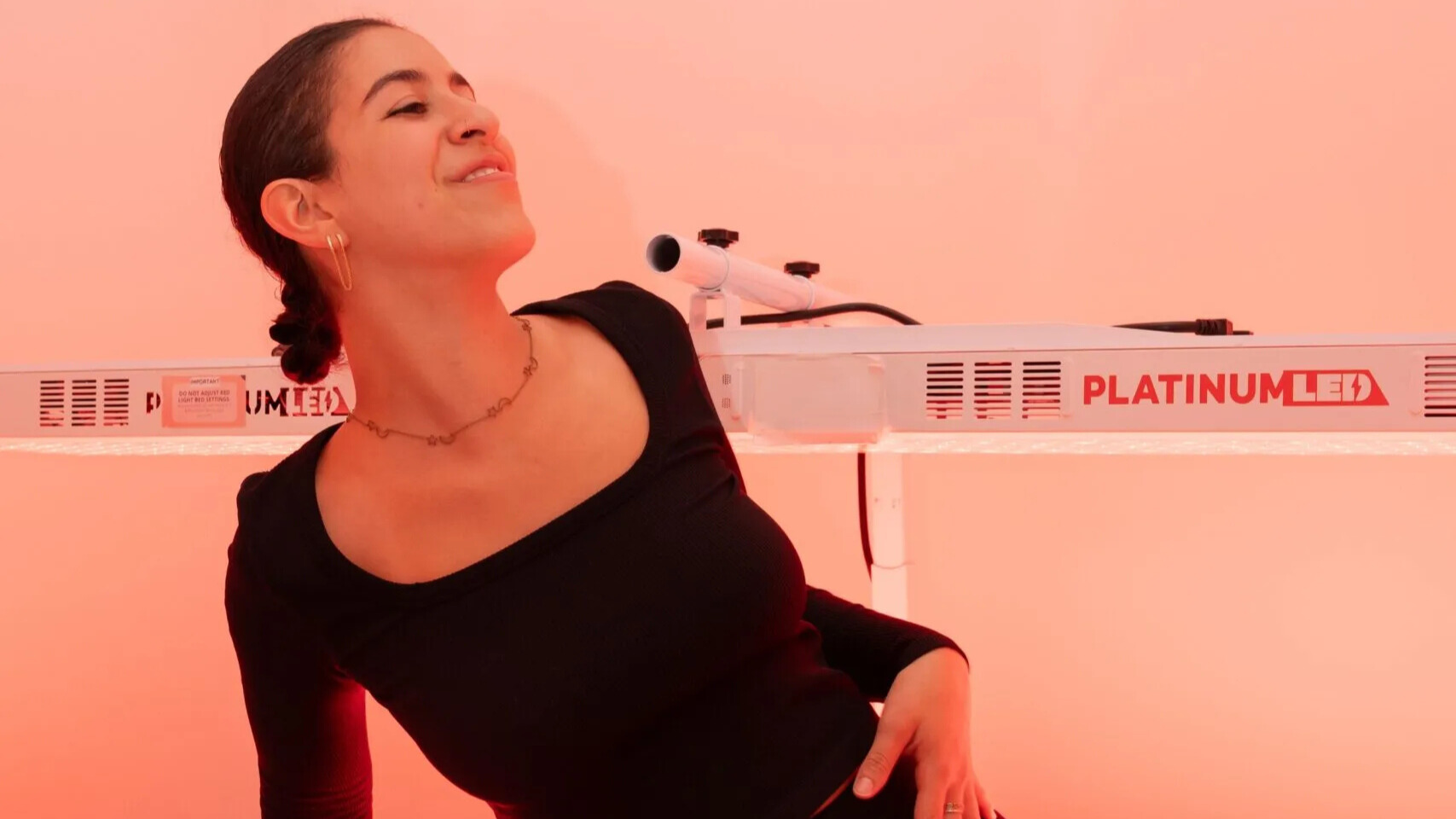 Woman starting to lie beneath red light for treatment.