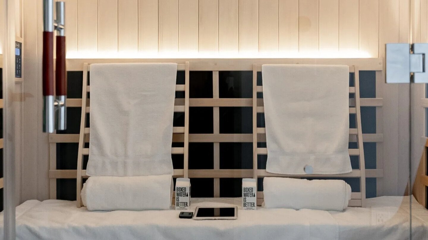 Luxury sauna with towels, water, and entertainment options for guests.